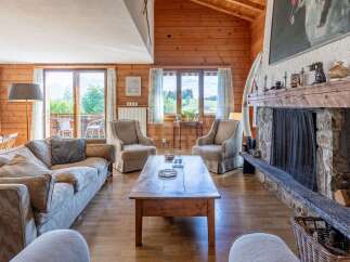 Experience rustic charm in this inviting living room, featuring a grand stone fireplace and warm wood paneling.