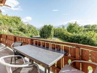 Enjoy breathtaking mountain views from this charming balcony, complete with a table and chairs for al fresco dining.