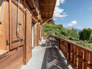Enjoy breathtaking mountain views from this charming wooden balcony, perfect for savoring your morning coffee or evening drinks.