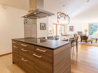 Experience modern living in this spacious open-concept home, featuring a sleek kitchen island with ample storage and a built-in stovetop.