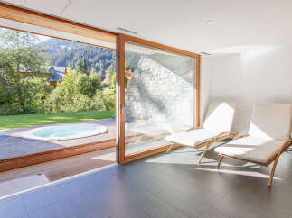 Experience ultimate relaxation in this luxurious indoor-outdoor spa area, featuring a private hot tub on a wooden deck with stunning mountain views.