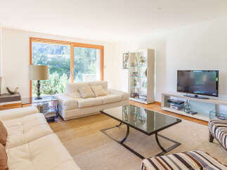 Experience modern living in this spacious living room, featuring a sleek fireplace and comfortable white leather sofas.