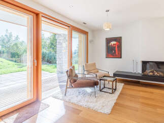 Experience seamless indoor-outdoor living with expansive sliding glass doors that open to a lush green backyard and a charming stone patio.