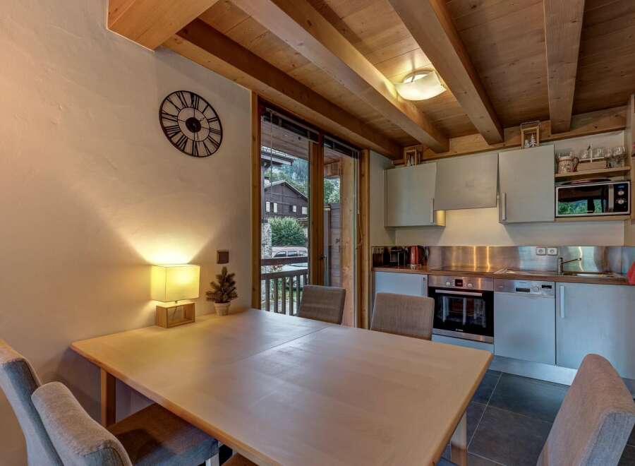 This charming dining area features a light wood table with comfortable upholstered chairs, perfect for family meals.