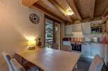 This charming dining area features a light wood table with comfortable upholstered chairs, perfect for family meals.