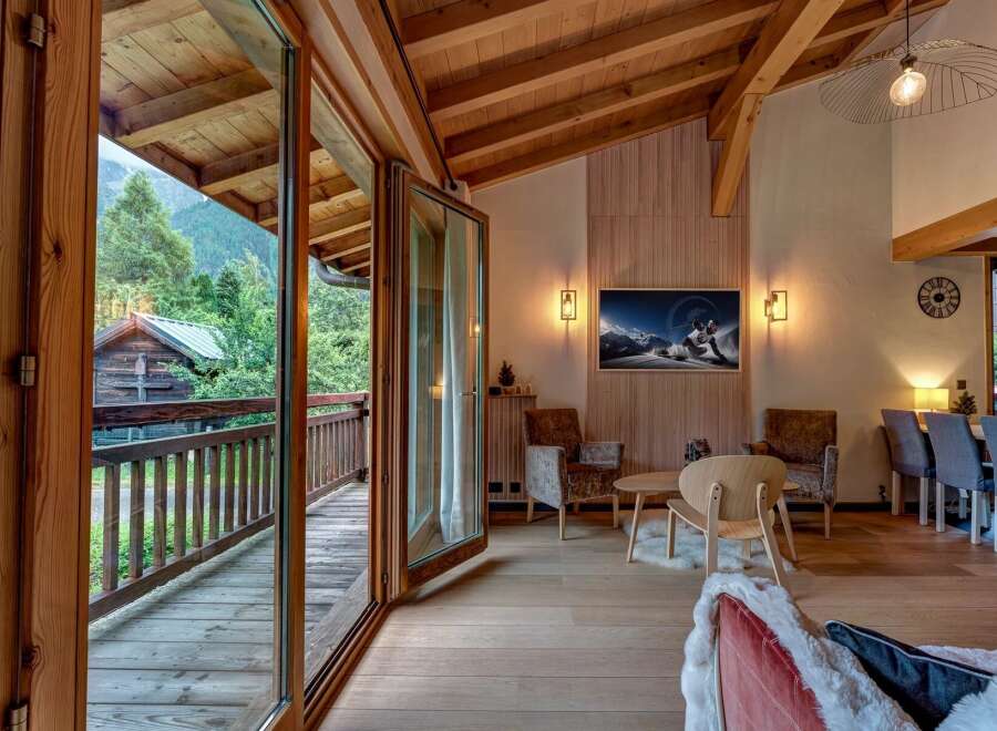 Experience mountain living in this stunning chalet, featuring a spacious open-plan living area with a cozy fireplace and breathtaking views.