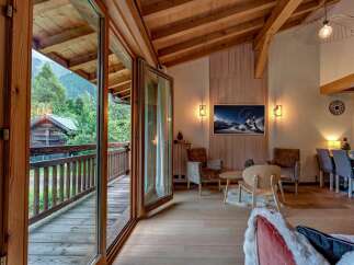 Experience mountain living in this stunning chalet, featuring a spacious open-plan living area with a cozy fireplace and breathtaking views.