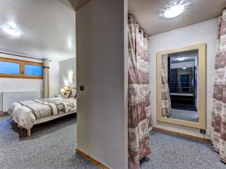 This charming bedroom features a comfortable bed with cozy linens, perfect for a restful night's sleep.