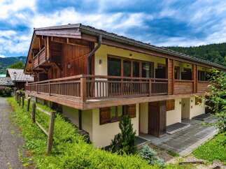Experience alpine living in this charming wooden chalet, featuring a spacious balcony perfect for enjoying mountain views.