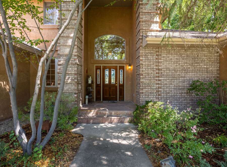 Welcome guests through a grand arched entryway, featuring a beautiful double wooden door with stained glass accents.