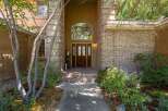 Welcome guests through a grand arched entryway, featuring a beautiful double wooden door with stained glass accents.