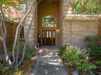 Welcome guests through a grand arched entryway, featuring a beautiful double wooden door with stained glass accents.