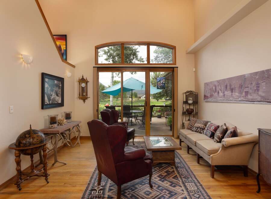 Experience the best of indoor-outdoor living in this stunning living room, featuring a grand fireplace and expansive sliding glass doors that open to a beautiful deck and backyard.