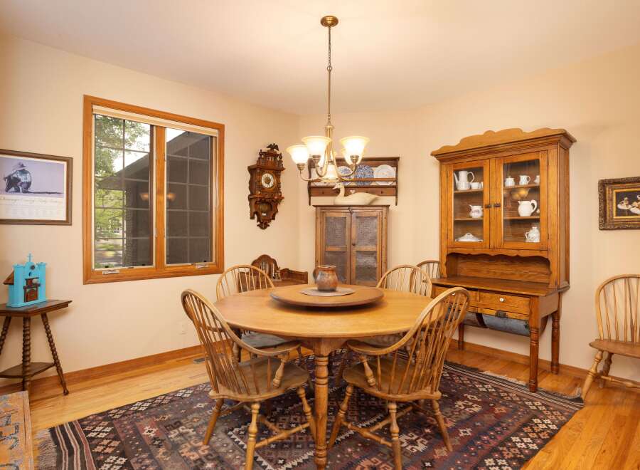 This charming dining room features a round wooden table with spindle-back chairs, perfect for intimate gatherings.