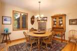 This charming dining room features a round wooden table with spindle-back chairs, perfect for intimate gatherings.