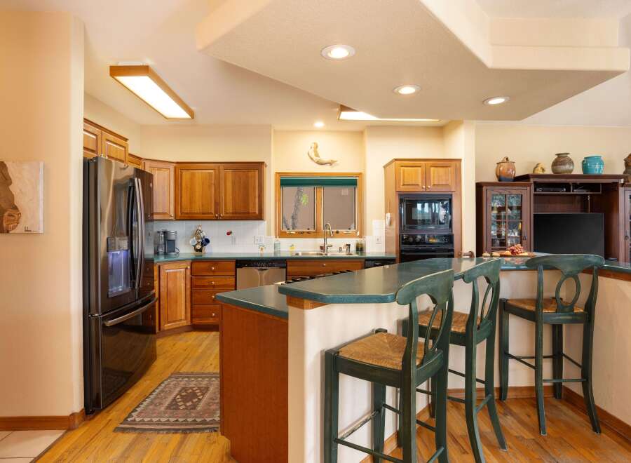 This spacious kitchen boasts beautiful wooden cabinetry and a sleek stainless steel refrigerator.