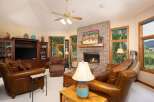 Cozy up by the brick fireplace in this inviting living room, featuring plush leather seating and a large entertainment center.