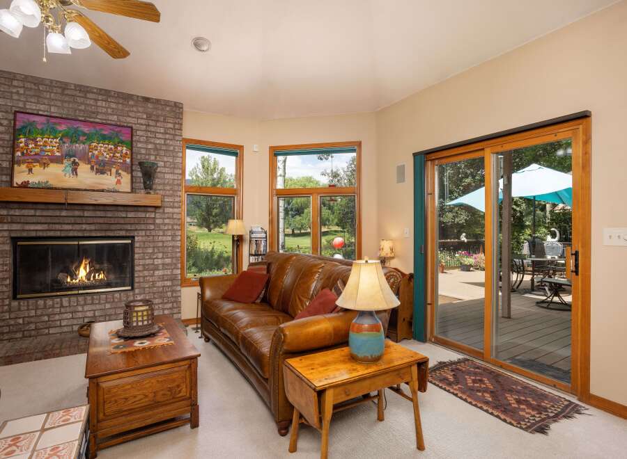 Cozy living room featuring a warm brick fireplace and a plush leather sofa, perfect for relaxing evenings.