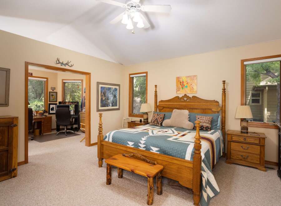 This spacious bedroom offers a comfortable retreat with a large wooden four-poster bed adorned with a Southwestern-style quilt.