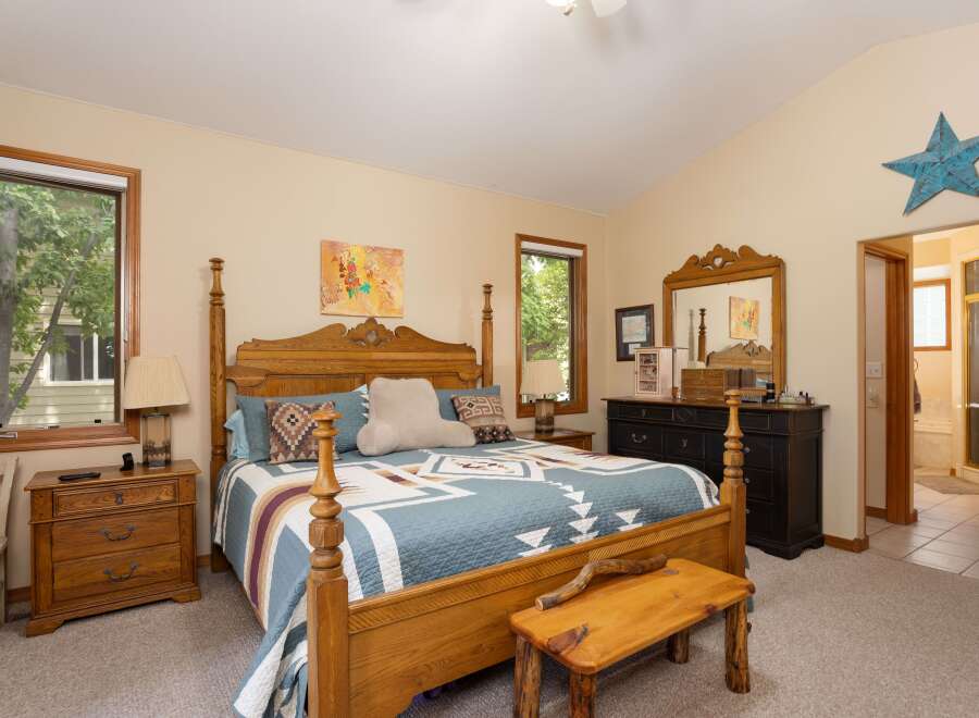 This charming bedroom features a beautiful wooden four-poster bed adorned with a Southwestern-inspired quilt and decorative pillows.
