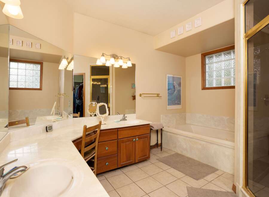 This spacious bathroom features a large vanity with dual sinks and ample counter space, perfect for busy mornings.