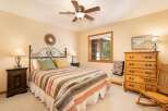 This charming bedroom features a comfortable queen-size bed with a colorful striped comforter and decorative pillows.