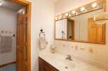 Charming bathroom featuring a wooden vanity with a marble countertop and a white sink.