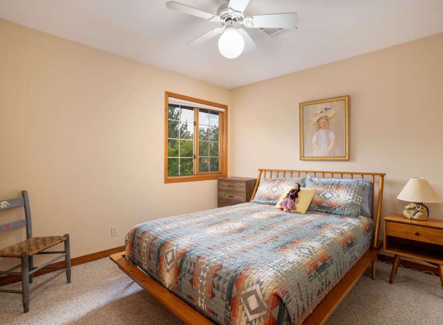 This cozy bedroom features a comfortable queen-size bed adorned with a Southwestern-inspired quilt and decorative pillows.