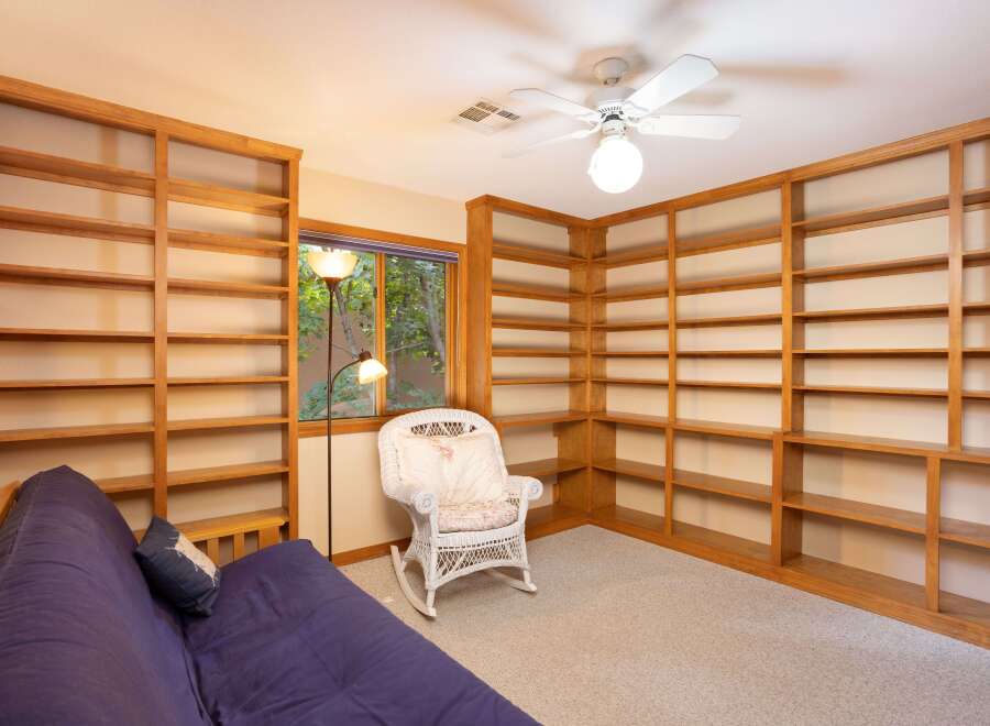 This room features extensive built-in wooden bookshelves, perfect for a home library or display space.