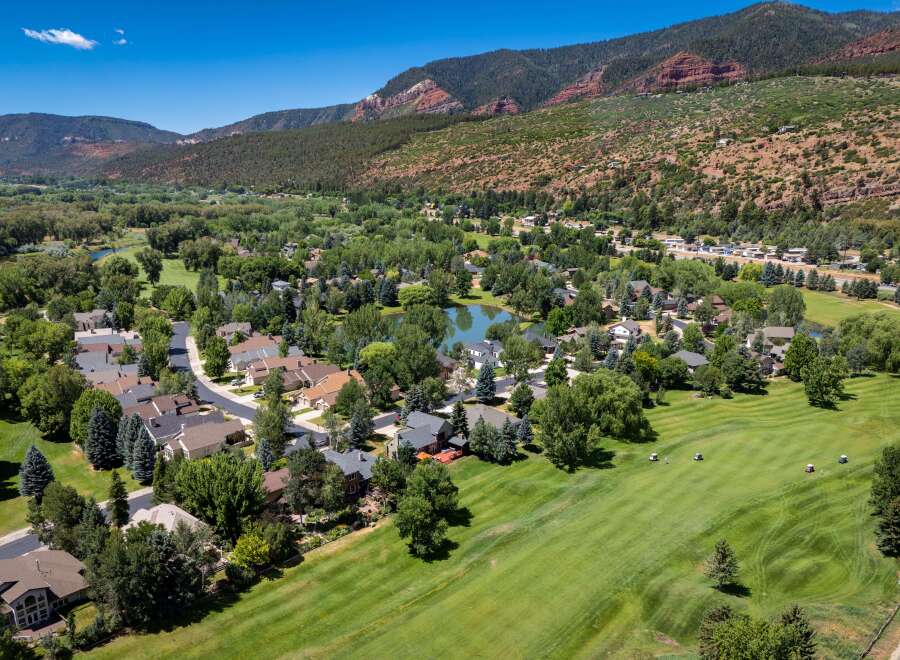 Experience luxury living in this stunning aerial view of a residential community nestled beside a pristine golf course.