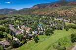 Experience luxury living in this stunning aerial view of a residential community nestled beside a pristine golf course.