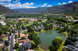 Discover this stunning aerial view of a picturesque suburban neighborhood nestled beside a serene lake and lush green golf course.