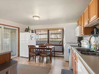 This charming kitchen features a dining area with a wooden table and chairs, perfect for family meals.