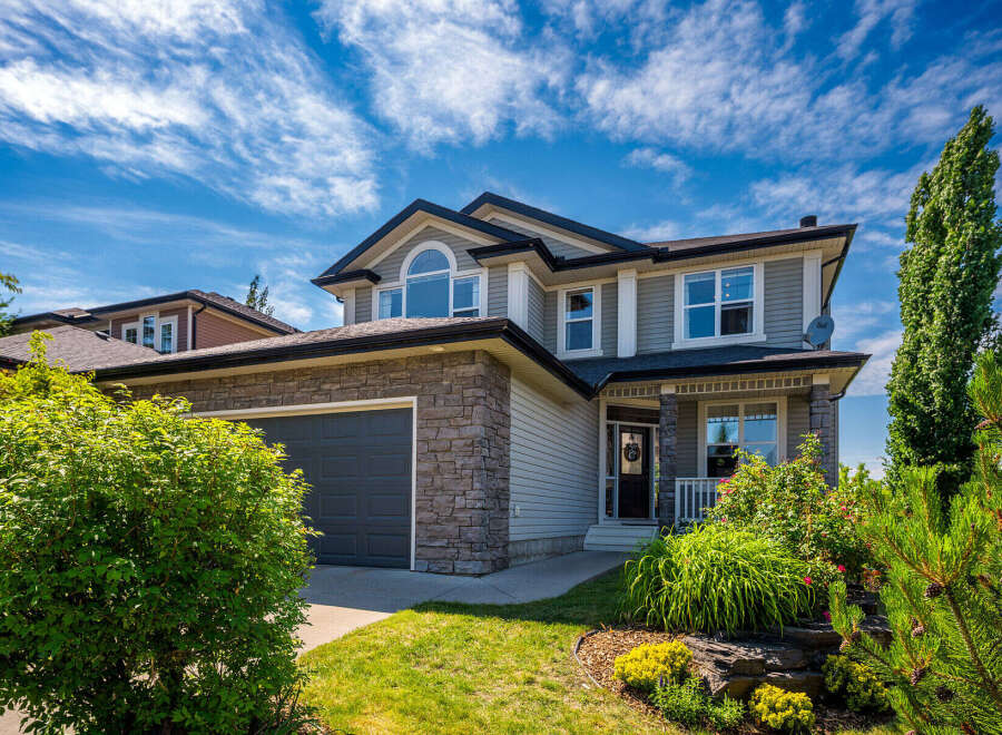 This stunning two-story home boasts a modern exterior with stone accents and a spacious two-car garage.