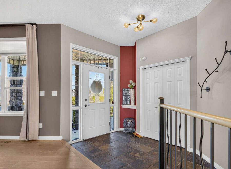 Step into this welcoming entryway featuring a bright white front door with decorative glass panels, perfect for letting in natural light.