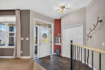 Step into this welcoming entryway featuring a bright white front door with decorative glass panels, perfect for letting in natural light.