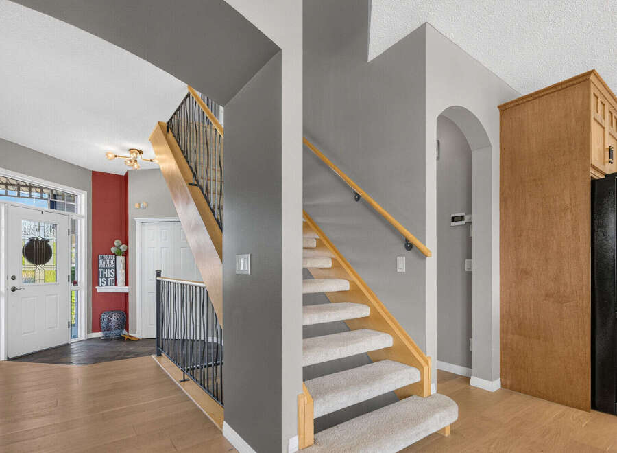 Step into a welcoming entryway featuring a bright front door with glass accents and a decorative wreath.