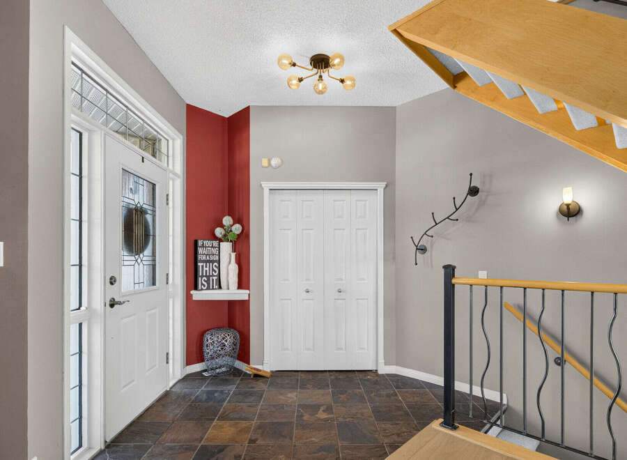 Step into a welcoming foyer featuring a bright white front door with decorative glass and a side window for natural light.
