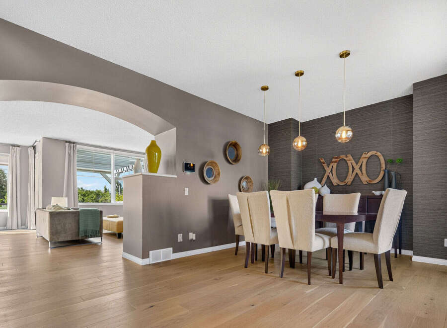 This elegant dining room features a dark wood dining table surrounded by upholstered chairs, perfect for hosting gatherings.