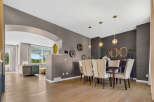 This elegant dining room features a dark wood dining table surrounded by upholstered chairs, perfect for hosting gatherings.