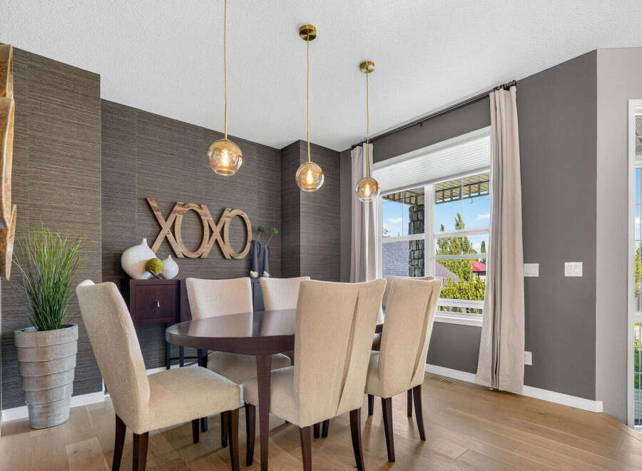 Elevate your dining experience in this elegant dining room, featuring a stylish dark wood table surrounded by upholstered chairs.