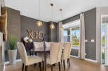 Elevate your dining experience in this elegant dining room, featuring a stylish dark wood table surrounded by upholstered chairs.