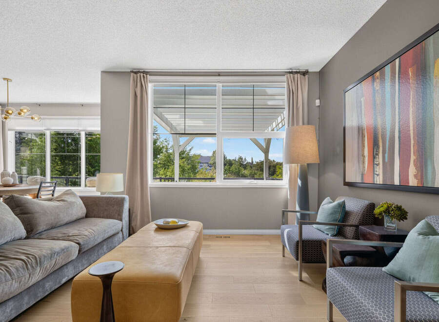 Experience modern living in this beautifully appointed living room, featuring a plush sectional sofa and a stylish leather ottoman perfect for relaxation.