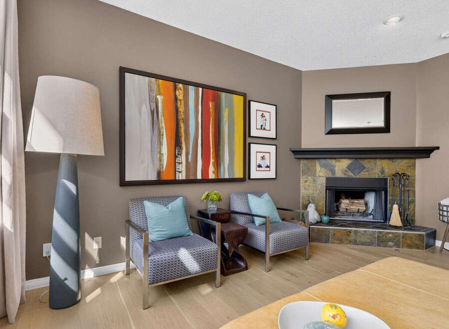 Experience modern living in this inviting living room, featuring a striking abstract art piece above two stylish armchairs.