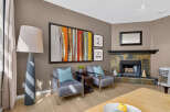 Experience modern living in this inviting living room, featuring a striking abstract art piece above two stylish armchairs.