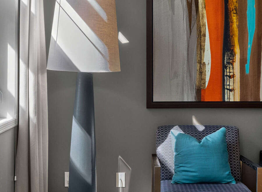 Experience modern living in this stylish room, featuring a striking abstract art piece that adds a vibrant pop of color.