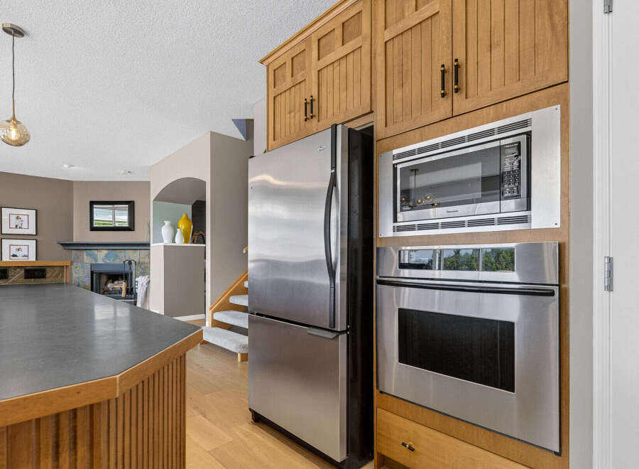 This spacious kitchen features stainless steel appliances, including a side-by-side refrigerator, a built-in microwave, and a modern oven.