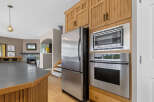 This spacious kitchen features stainless steel appliances, including a side-by-side refrigerator, a built-in microwave, and a modern oven.