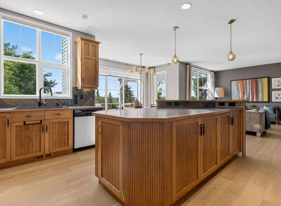 This spacious kitchen boasts beautiful natural wood cabinetry and a large island, perfect for entertaining.