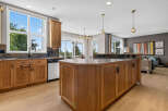This spacious kitchen boasts beautiful natural wood cabinetry and a large island, perfect for entertaining.